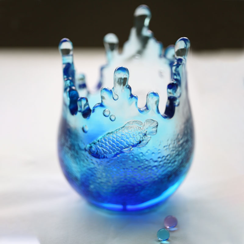 Balık desenleriyle işlenmiş mavi cam süs eşyaları
